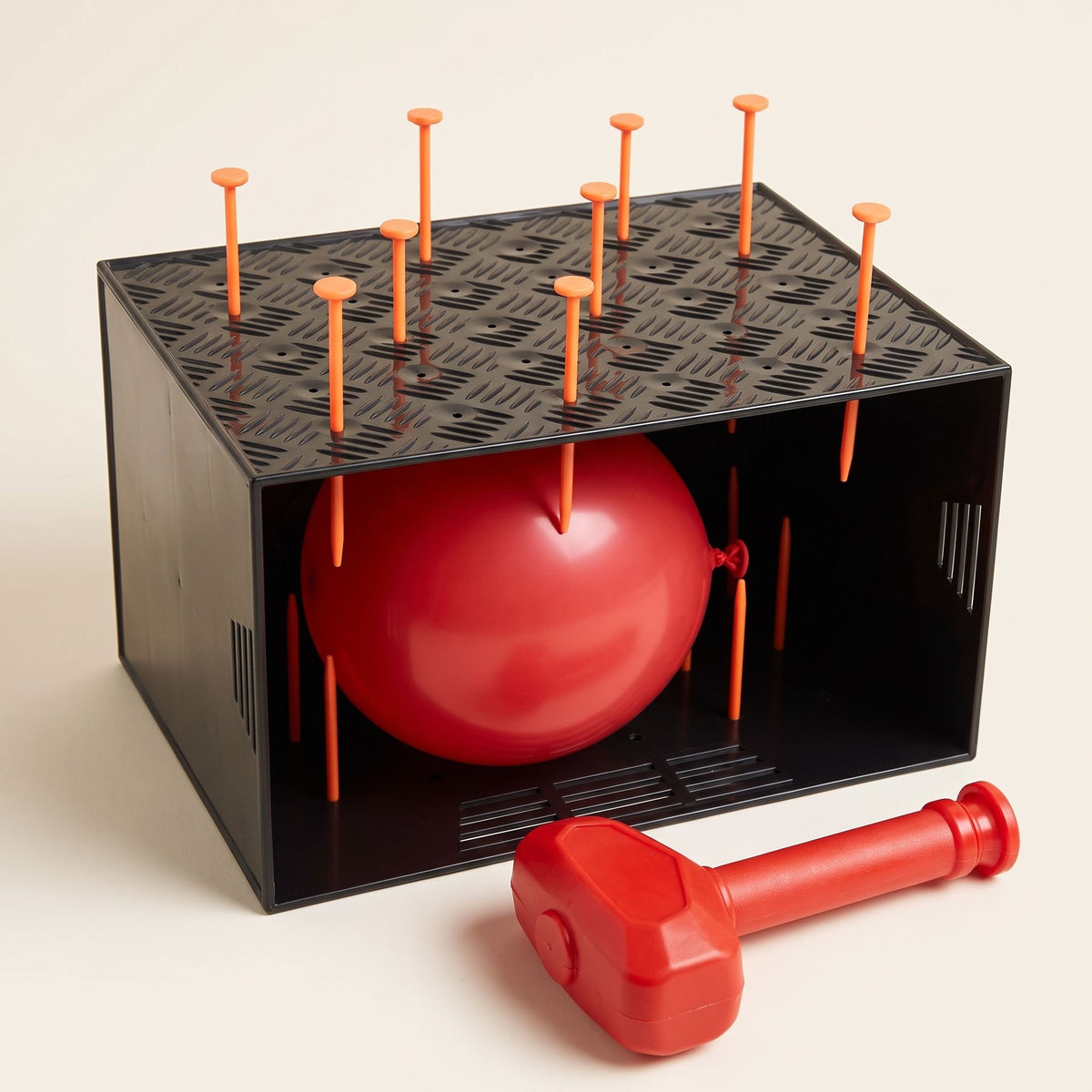 The LastPops game box seen from a three-quarter angle with a red balloon and nails in the lid
